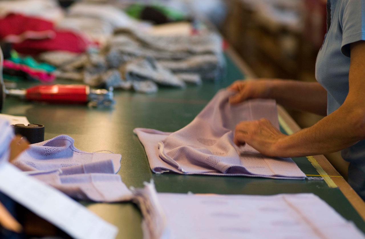 woman folds garment together - cultural sustainability
